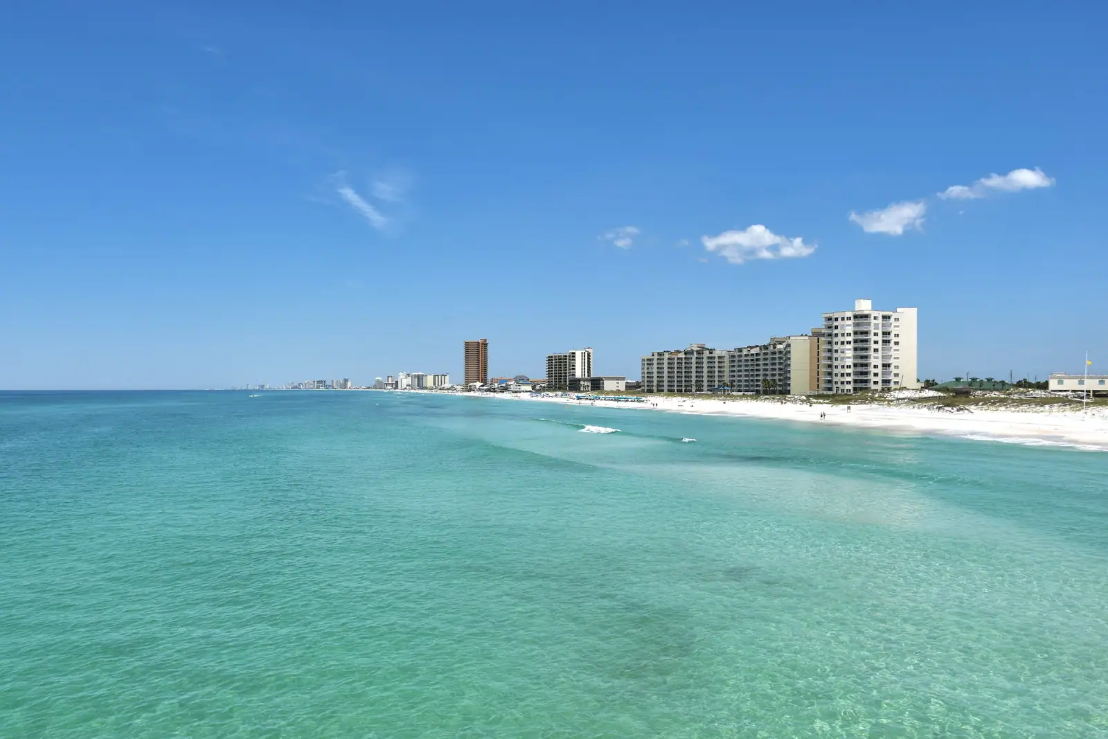 Clear green Gulf water and beachfront towers in Panama City Beach